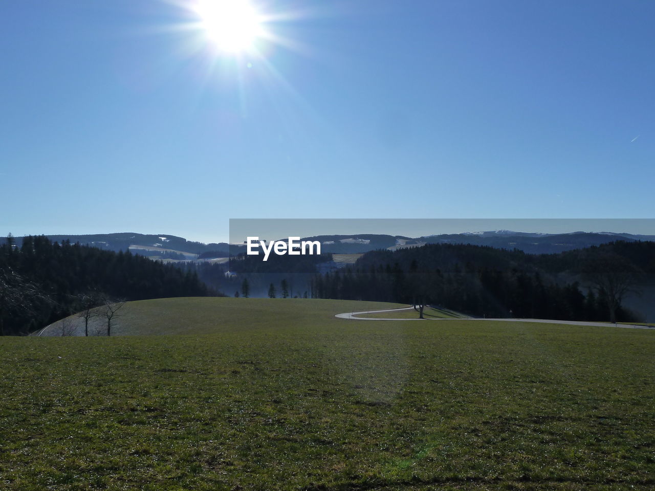 Scenic view of landscape against sky on sunny day