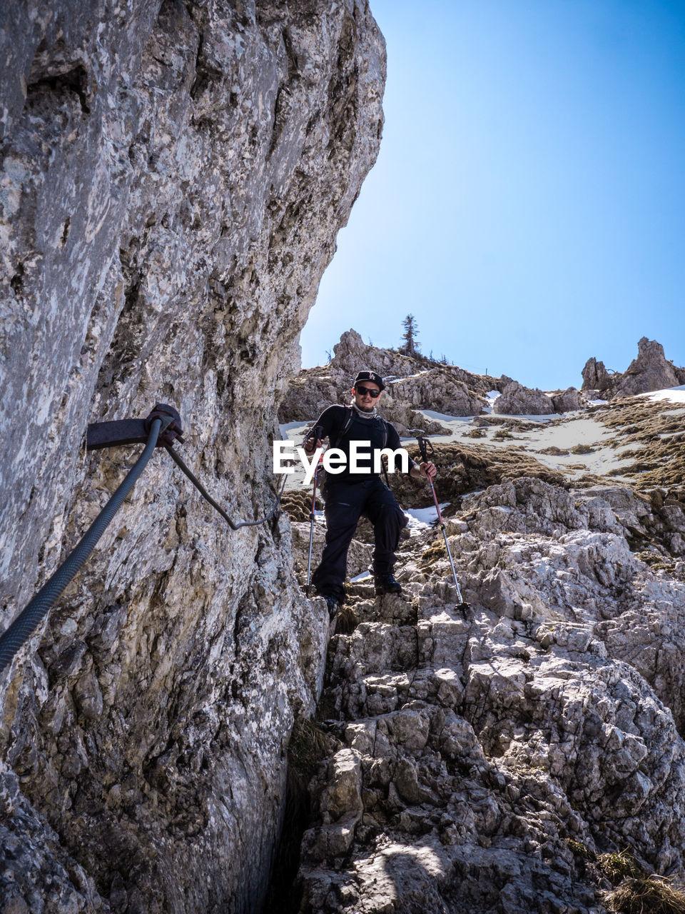 LOW ANGLE VIEW OF MAN AGAINST MOUNTAIN