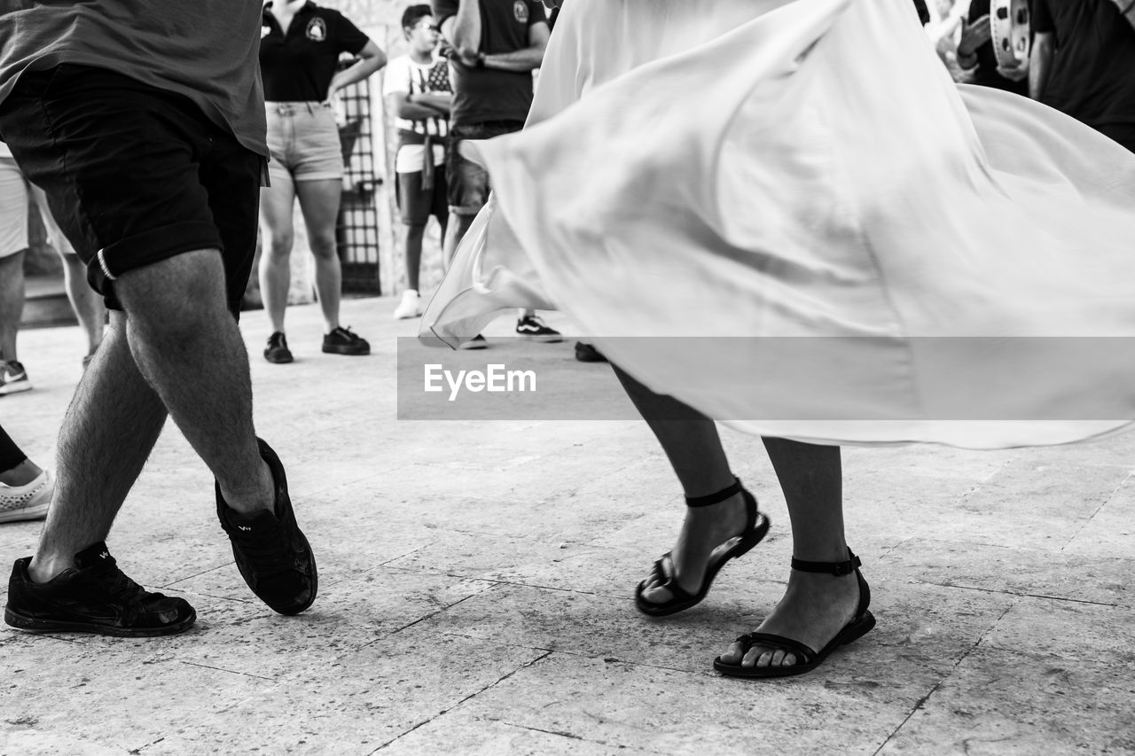 Low section of couple dancing on street