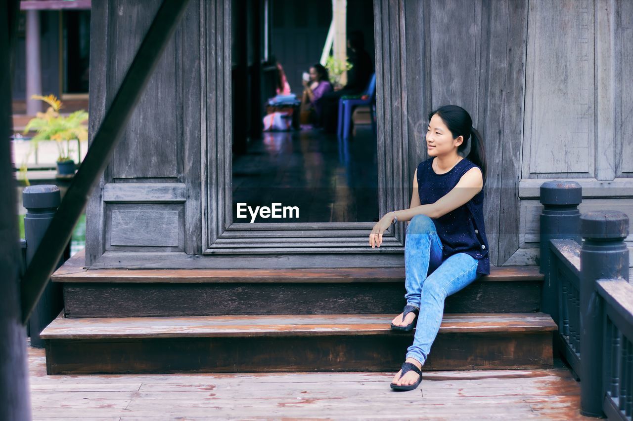 Thoughtful mid adult woman sitting on steps