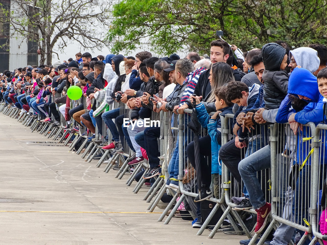 GROUP OF PEOPLE WAITING FOR SALE AT STREET