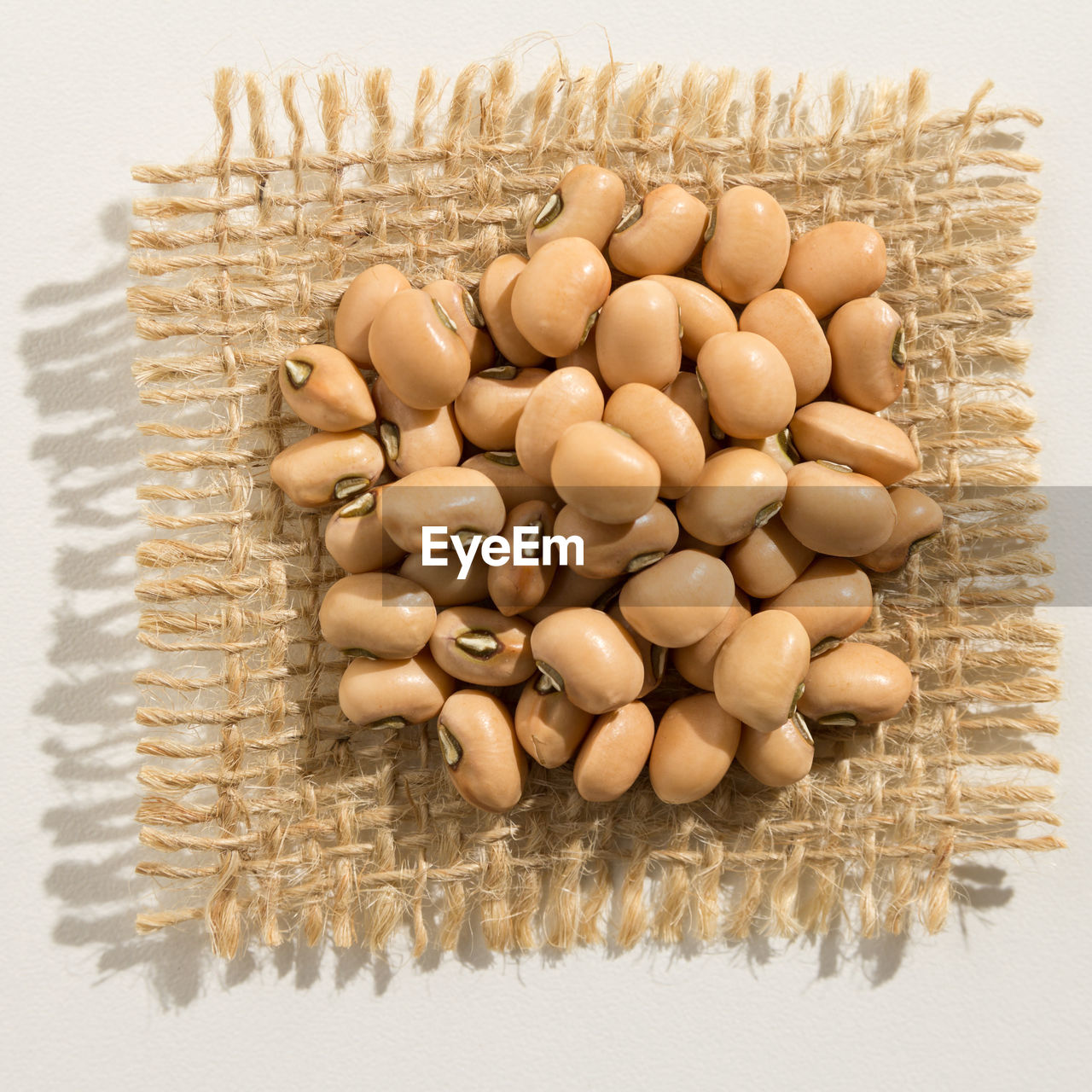 Close-up of beans on jute against white background