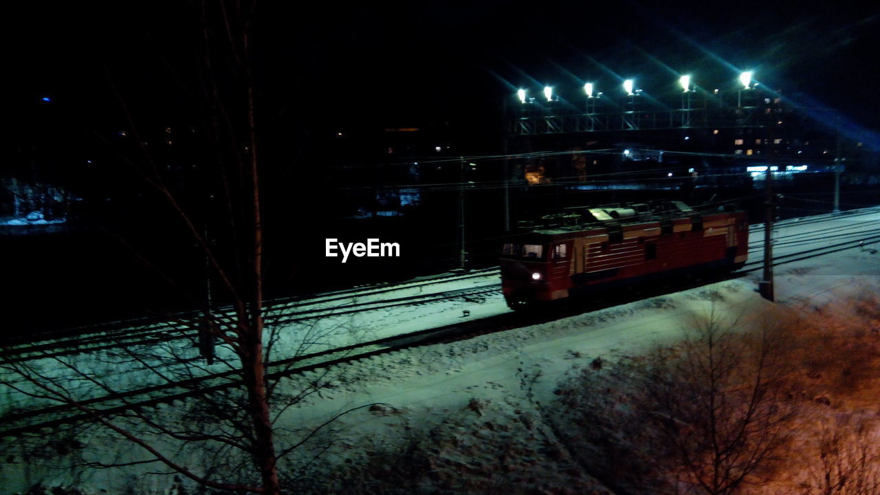 Train on railroad tracks at night during winter