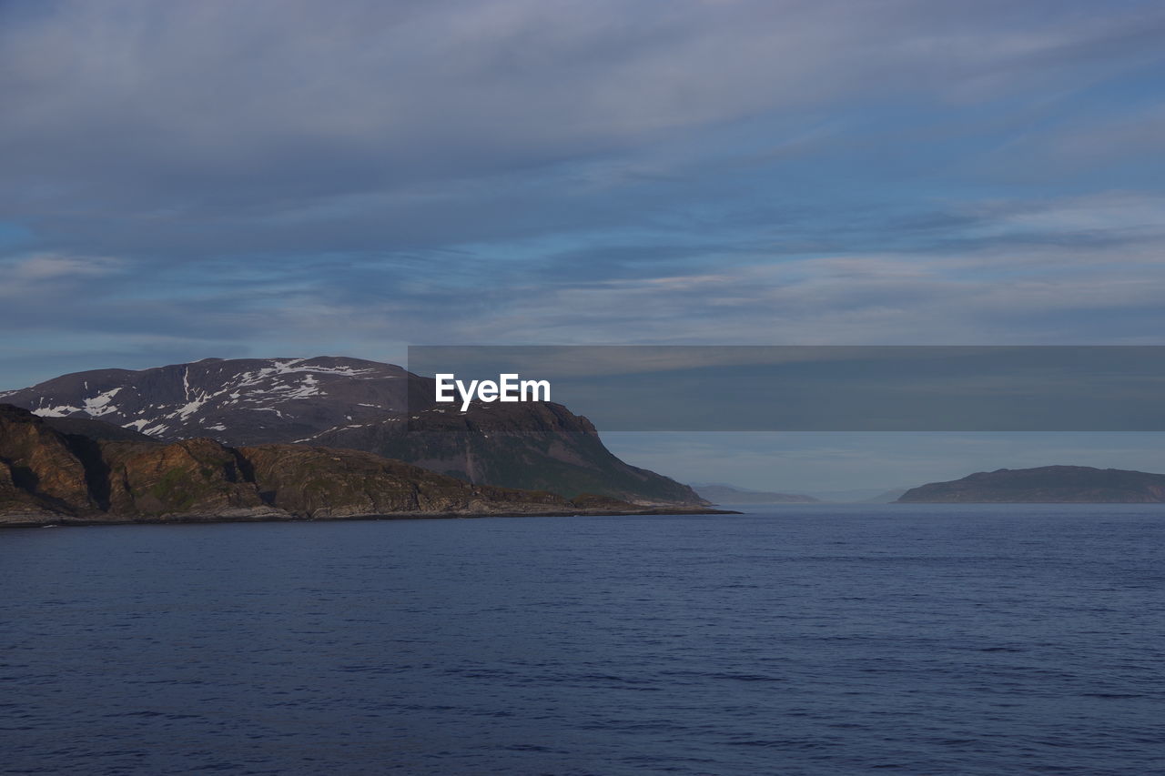 SCENIC VIEW OF SEA AND MOUNTAIN AGAINST SKY