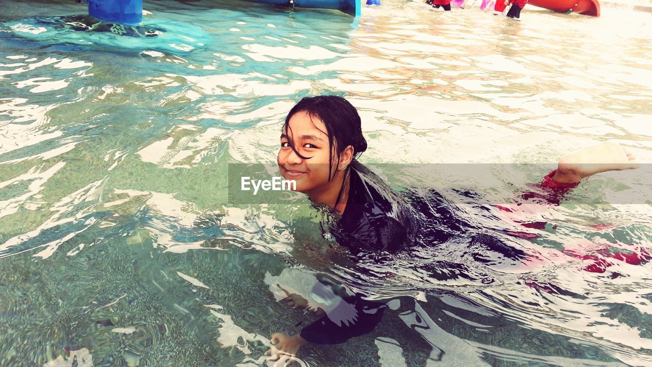 Portrait of smiling girl swimming in pool