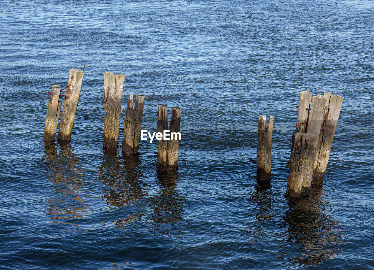 water, shore, sea, wood, ocean, reflection, coast, no people, nature, wave, wooden post, day, post, outdoors, tranquility, beauty in nature, horizon, driftwood, rock