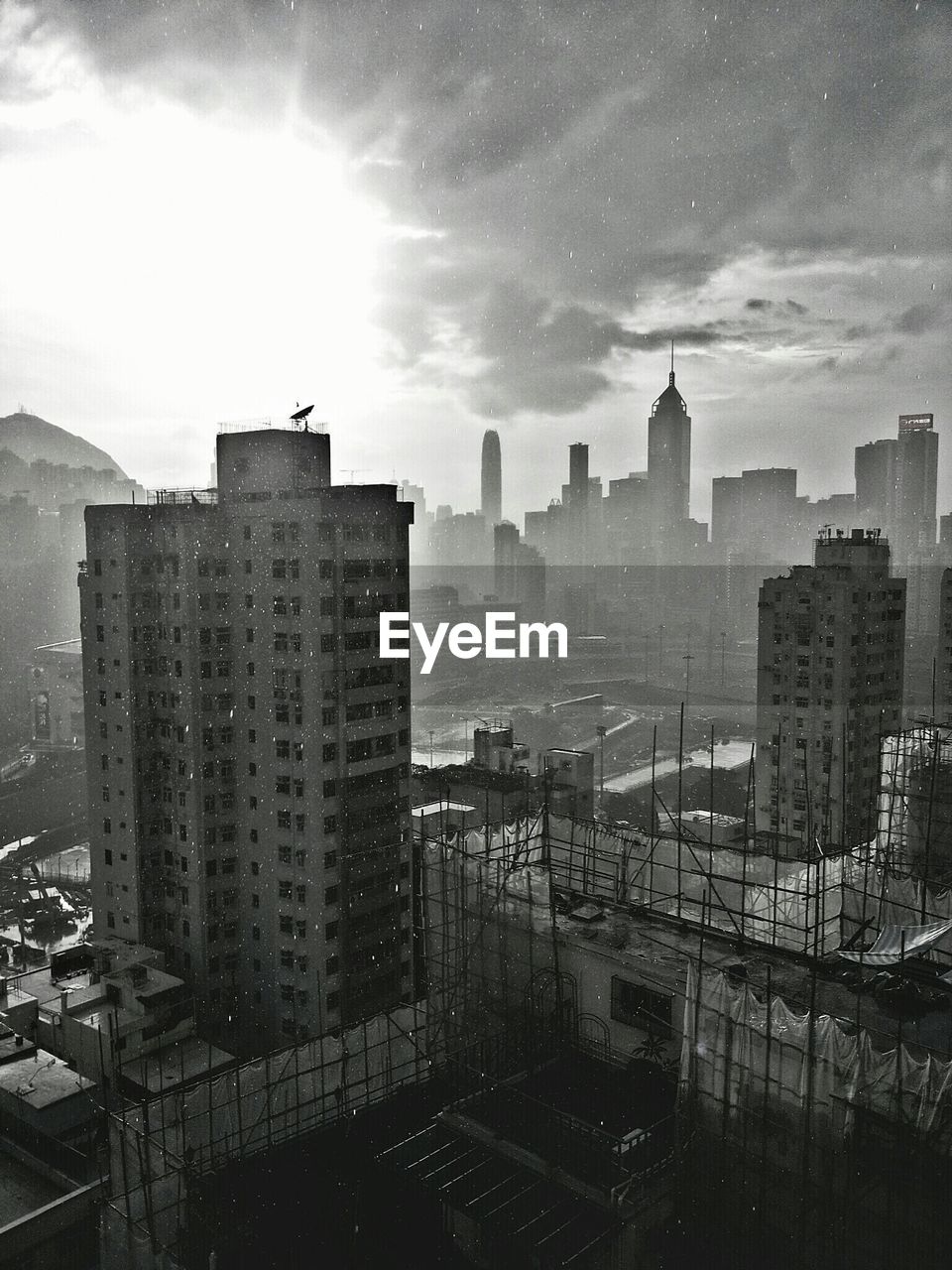 Skyscrapers in city against cloudy sky