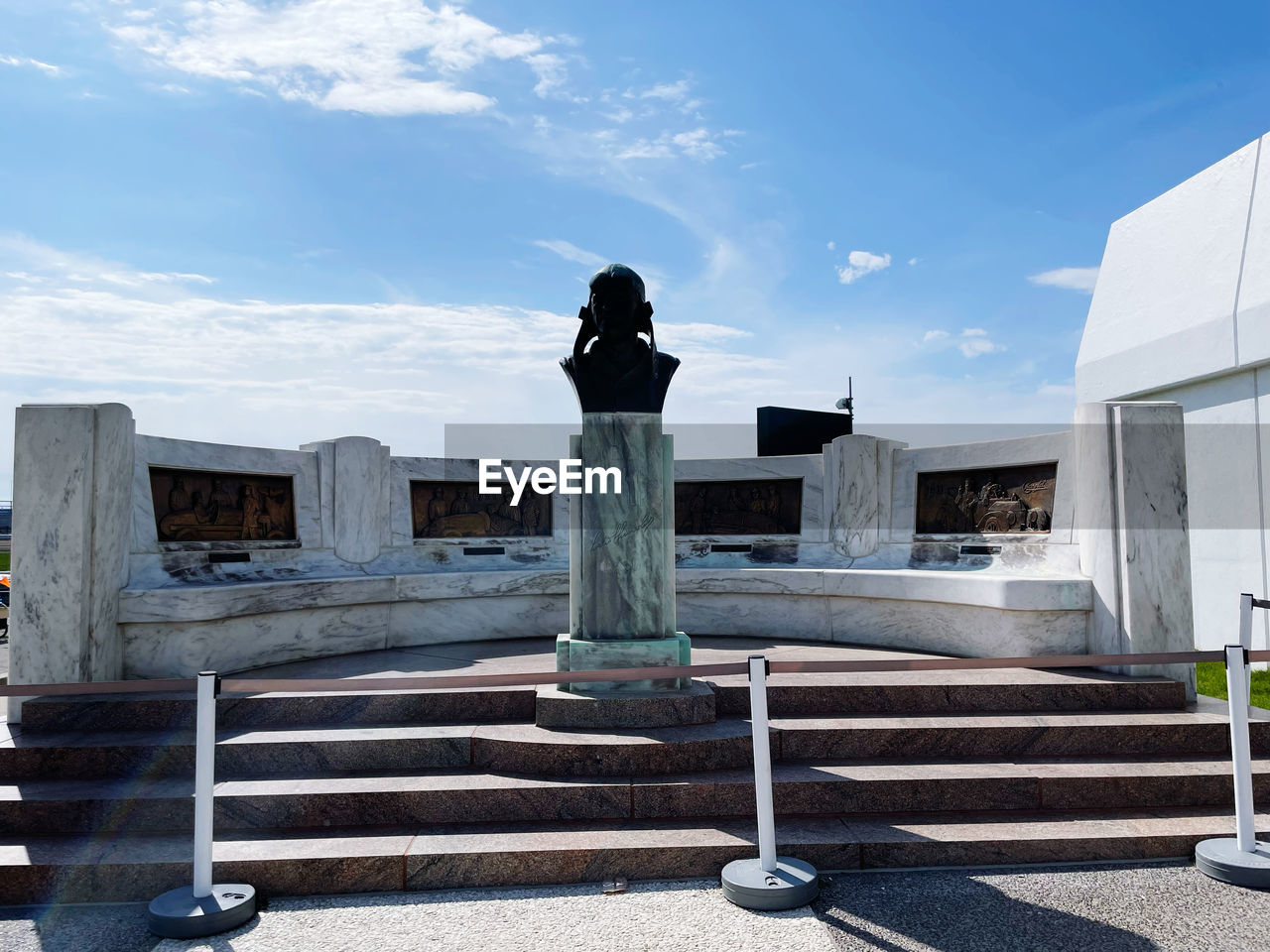 architecture, sky, staircase, statue, nature, cloud, built structure, day, sculpture, one person, monument, memorial, outdoors, sunlight, building exterior, full length, blue, adult, steps and staircases, city