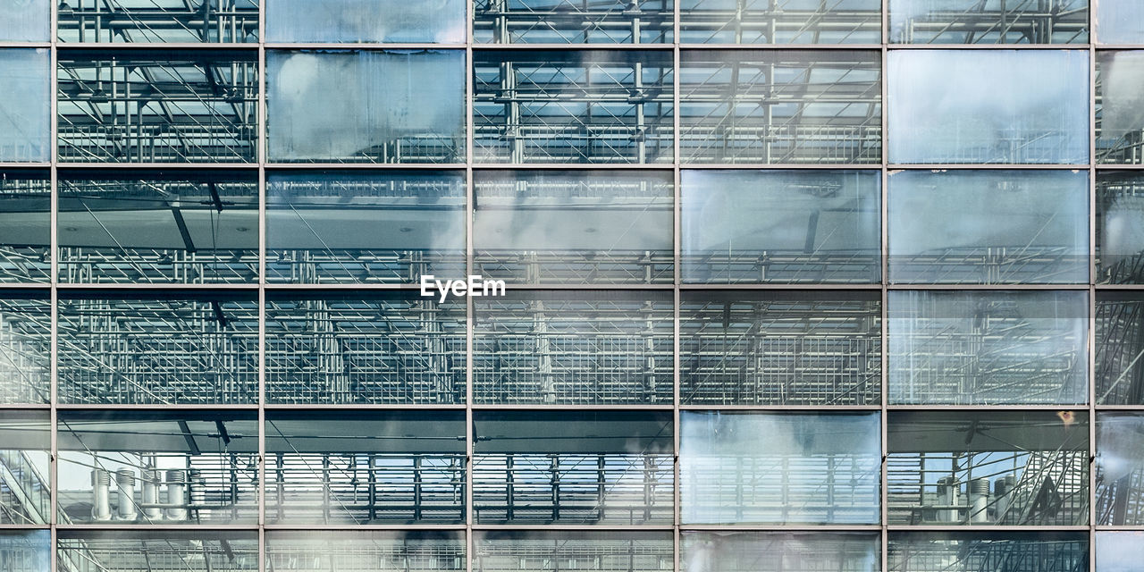 Low angle view of glass building against sky