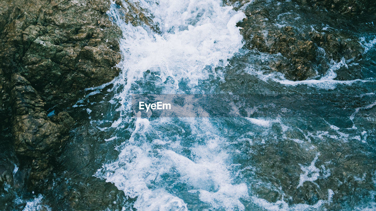 High angle view of water flowing through rocks