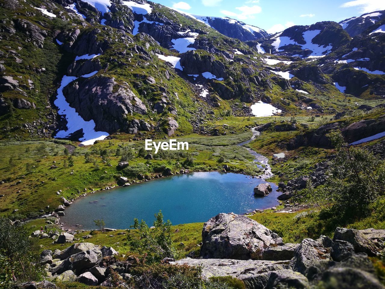 High angle view of pond by mountains during winter