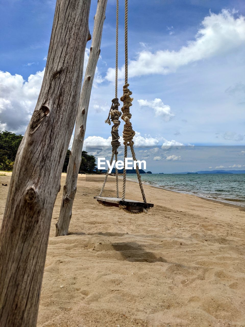 sky, land, beach, sea, cloud, water, nature, sand, scenics - nature, day, tree, shore, wood, beauty in nature, outdoors, tranquility, rope, horizon, ocean, tranquil scene, coast, no people, horizon over water, mast, sunlight, holiday, vacation, plant, swing