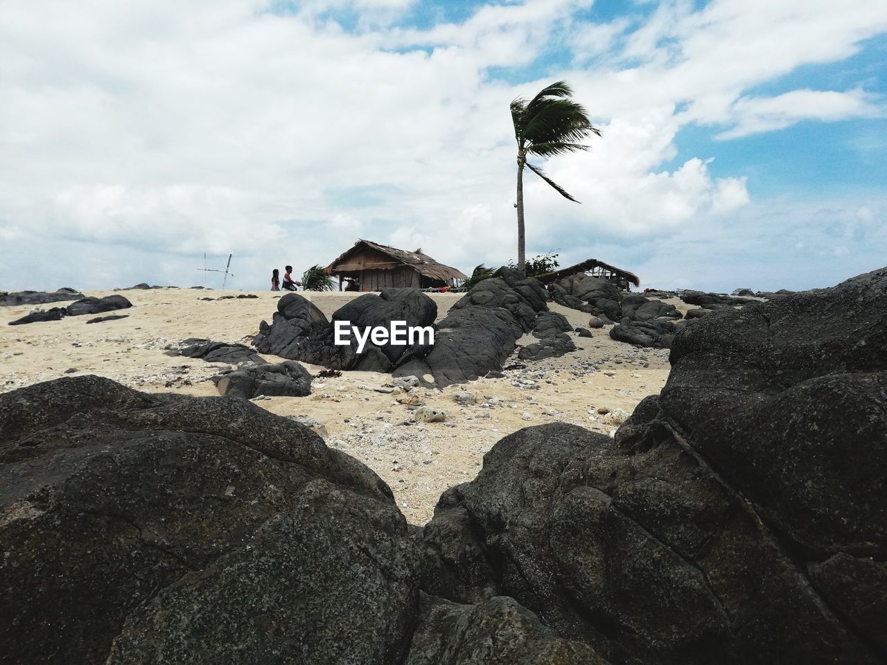 ROCK FORMATIONS ON SHORE AGAINST SKY