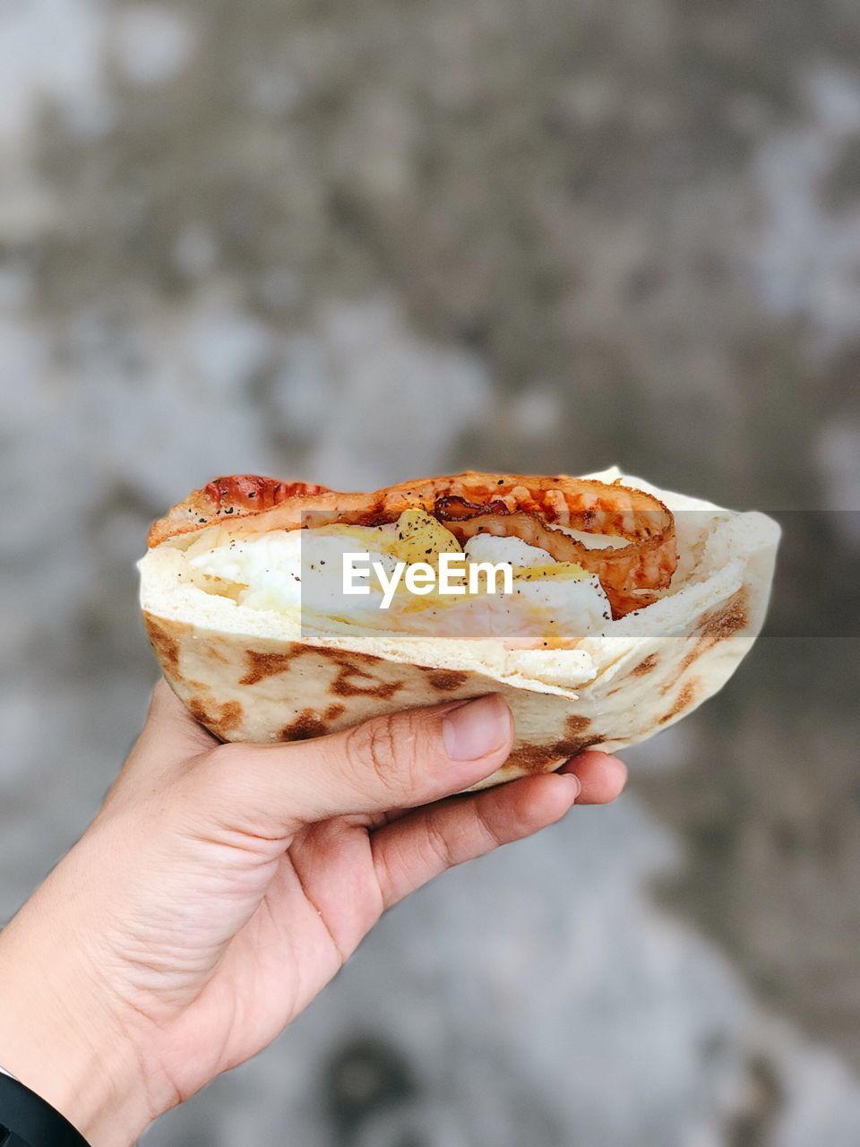 CLOSE-UP OF A HAND HOLDING BREAD