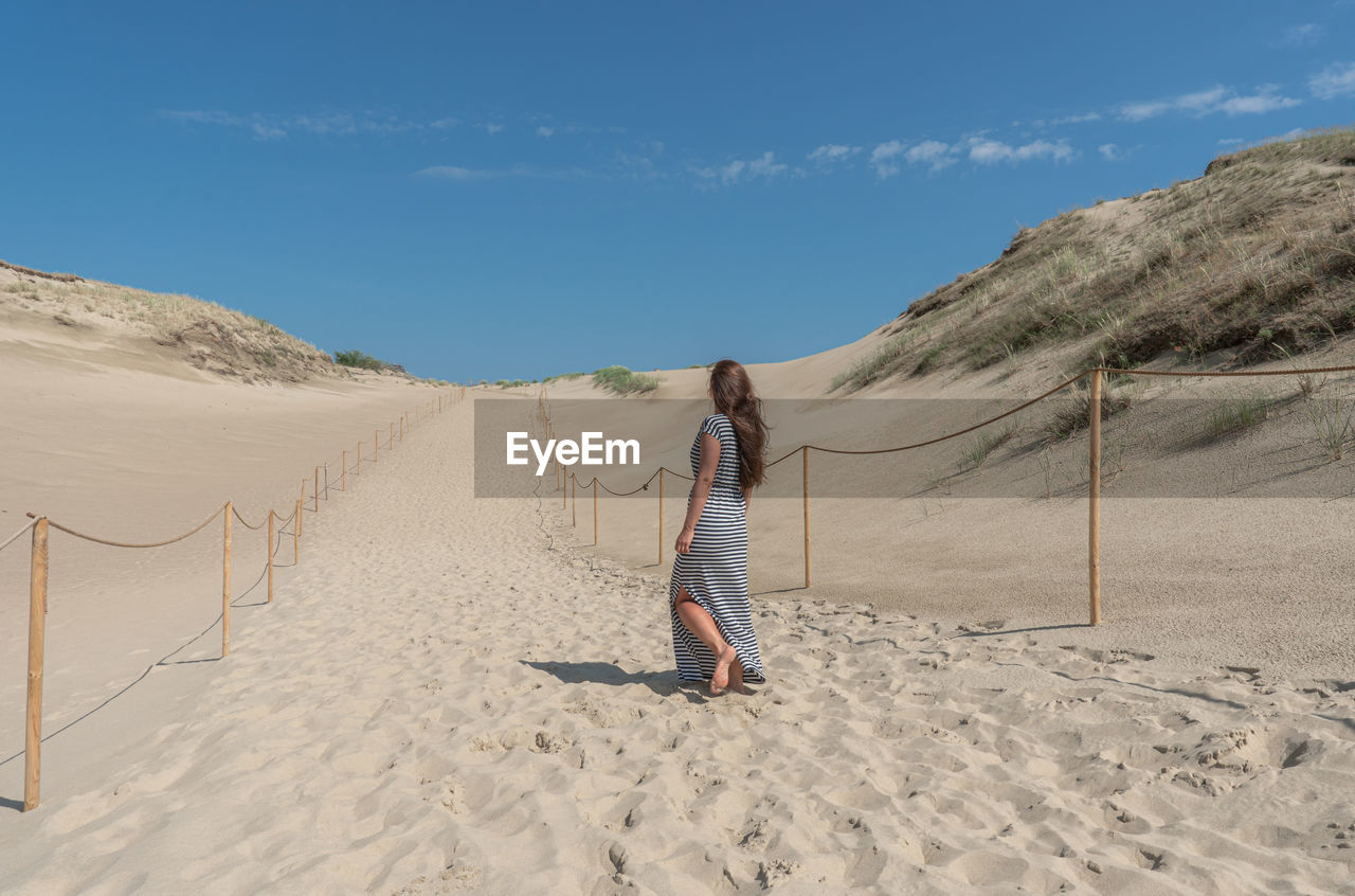 REAR VIEW OF MAN ON BEACH