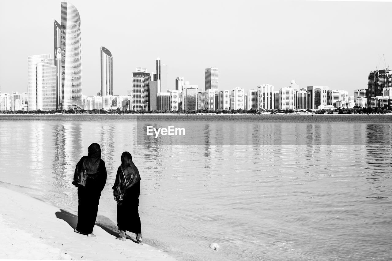 Muslim women standing on beach