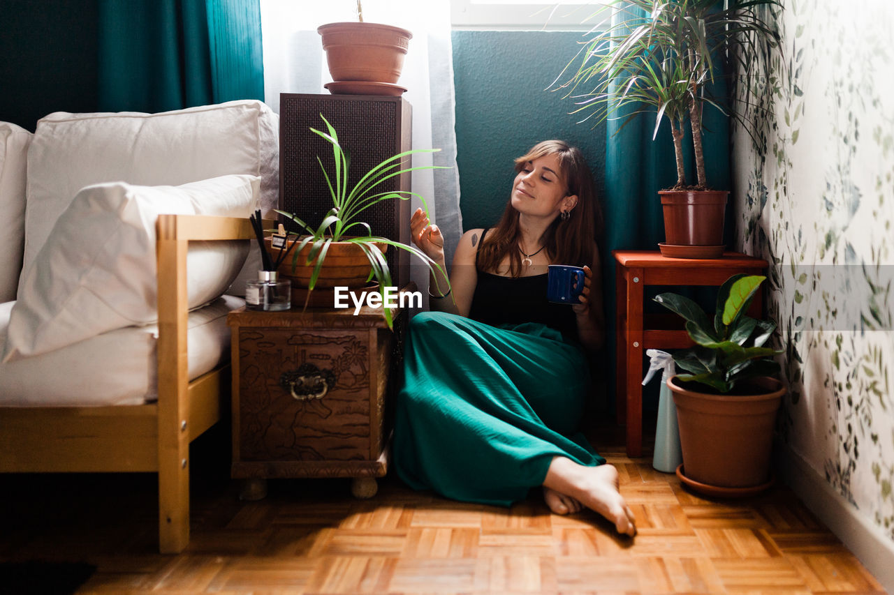 Young woman sitting on sofa at home