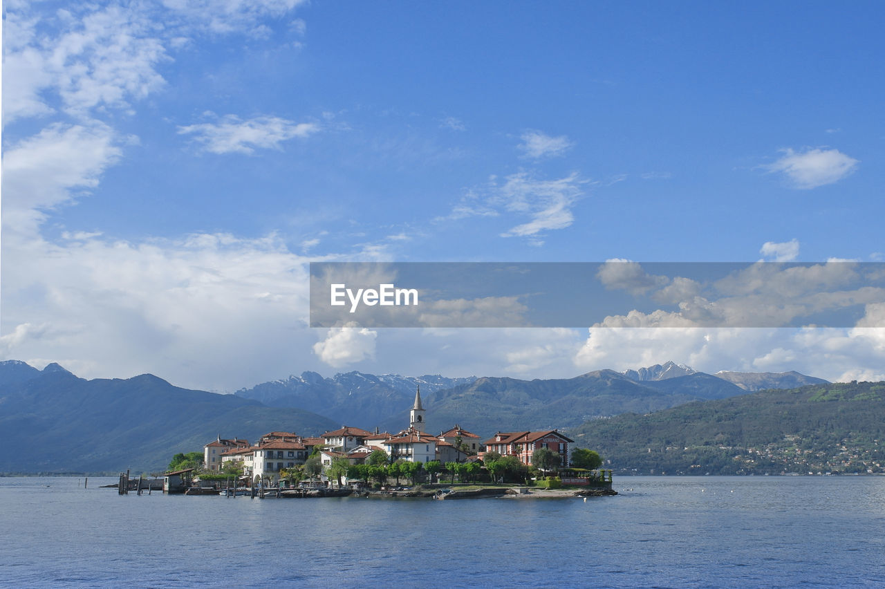 Scenic view of sea by buildings against sky