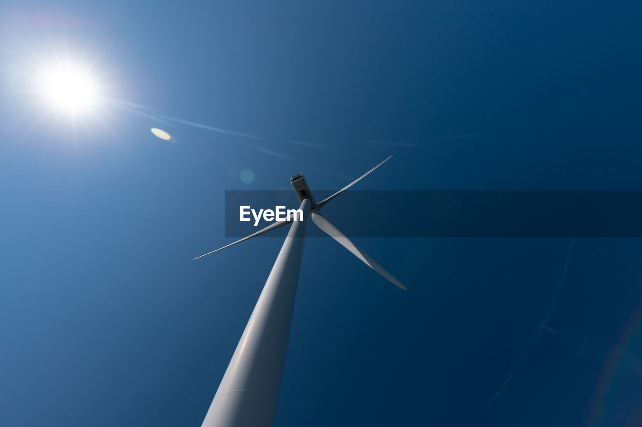 LOW ANGLE VIEW OF WINDMILL AGAINST BLUE SKY