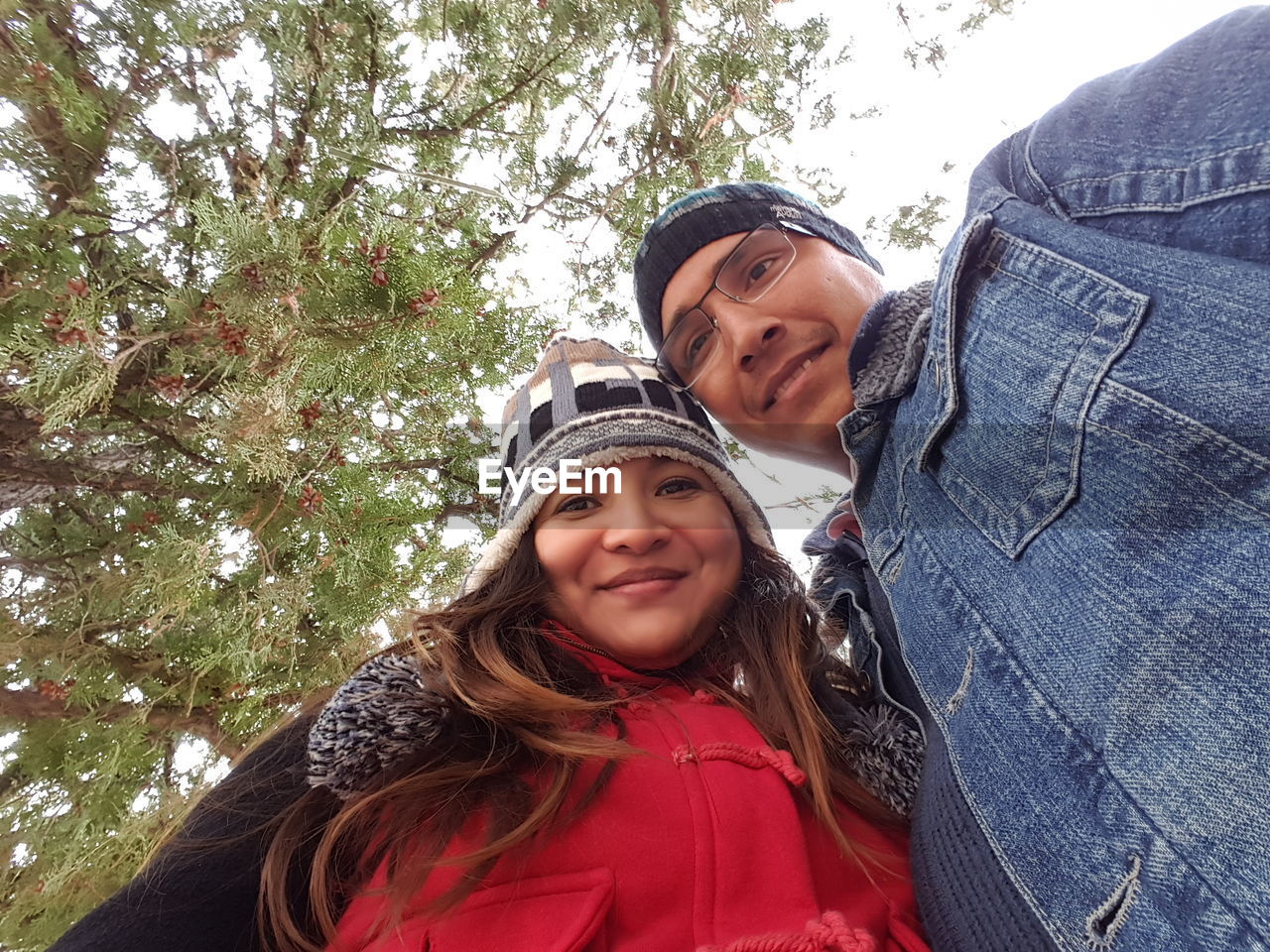 Portrait of couple standing against tree