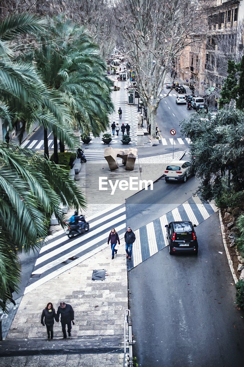 HIGH ANGLE VIEW OF PEOPLE WALKING ON ROAD IN CITY