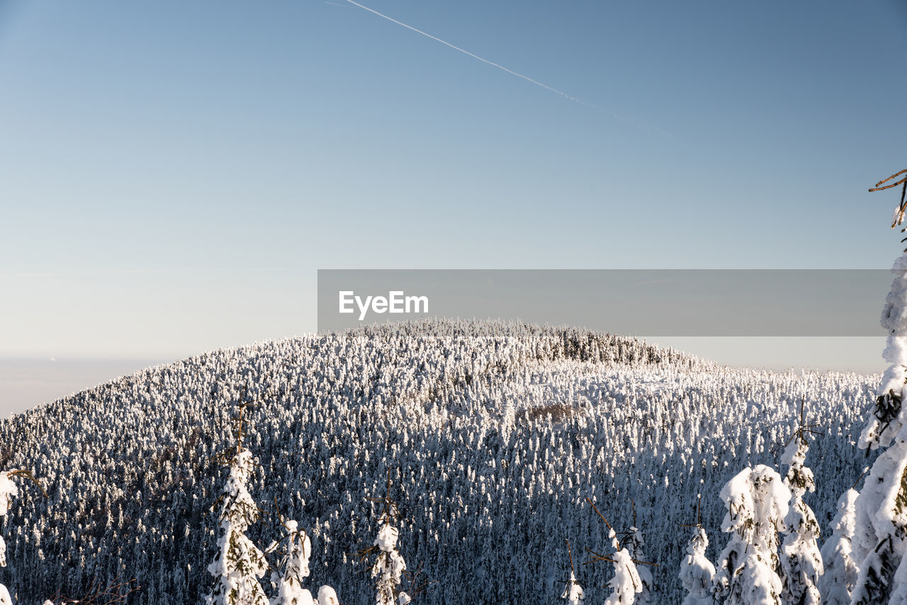 SNOW COVERED LAND AGAINST CLEAR SKY