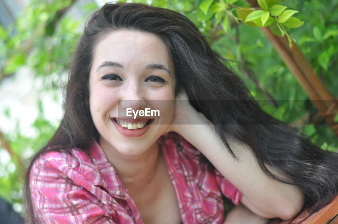 Portrait of smiling young woman with black hair