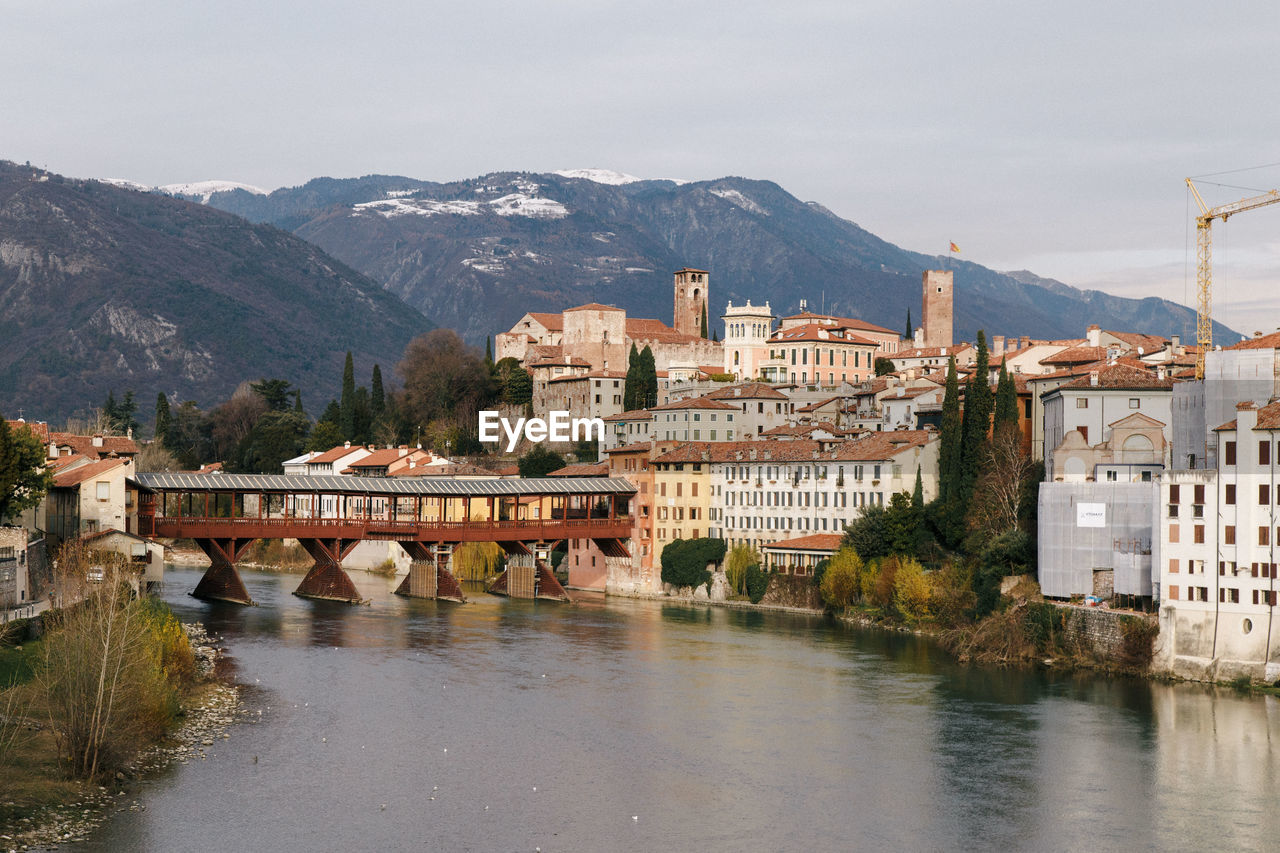 River by houses in town against sky