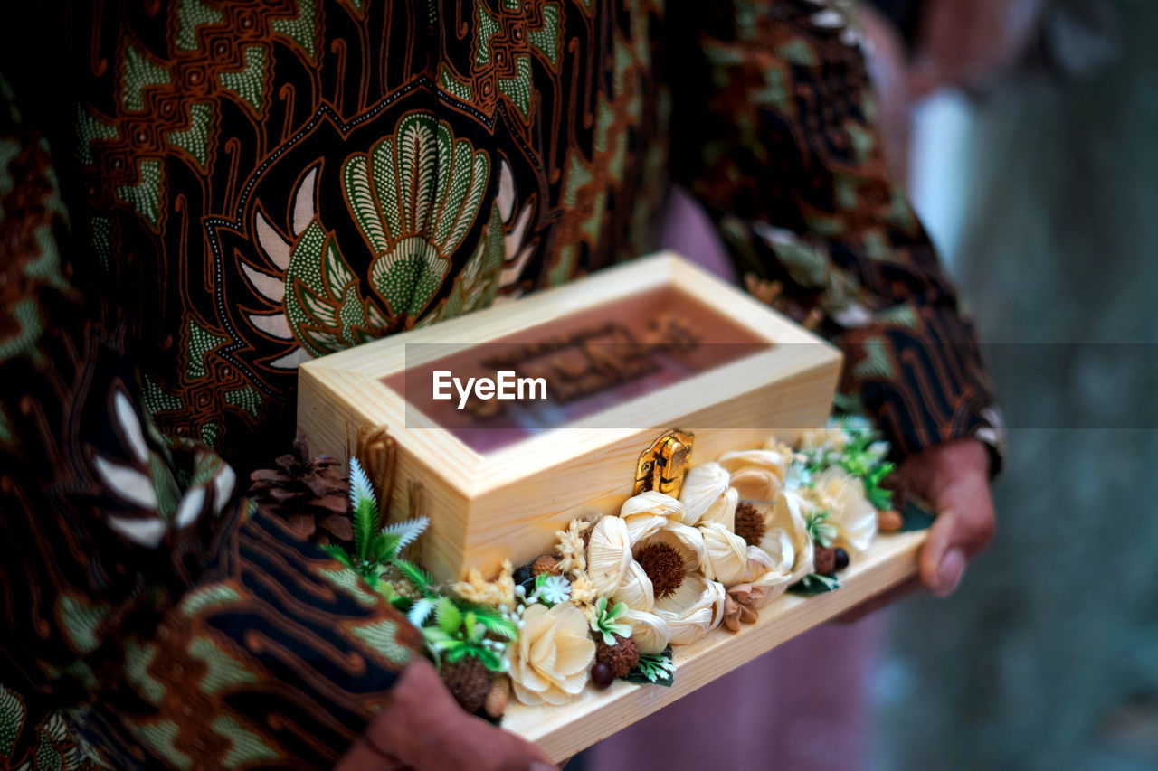 Cropped hand of a man holding wedding gift box 