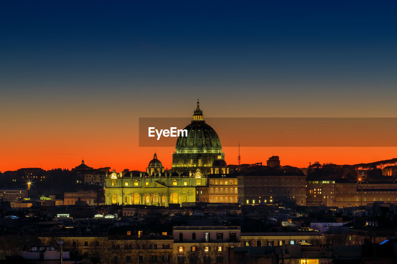 Sunset on the skyline of rome city, with the dome of st. peter's cathedral in the center.
