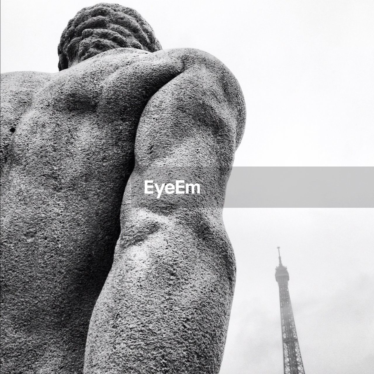 Low angle view of statue in front of eiffel tower against clear sky