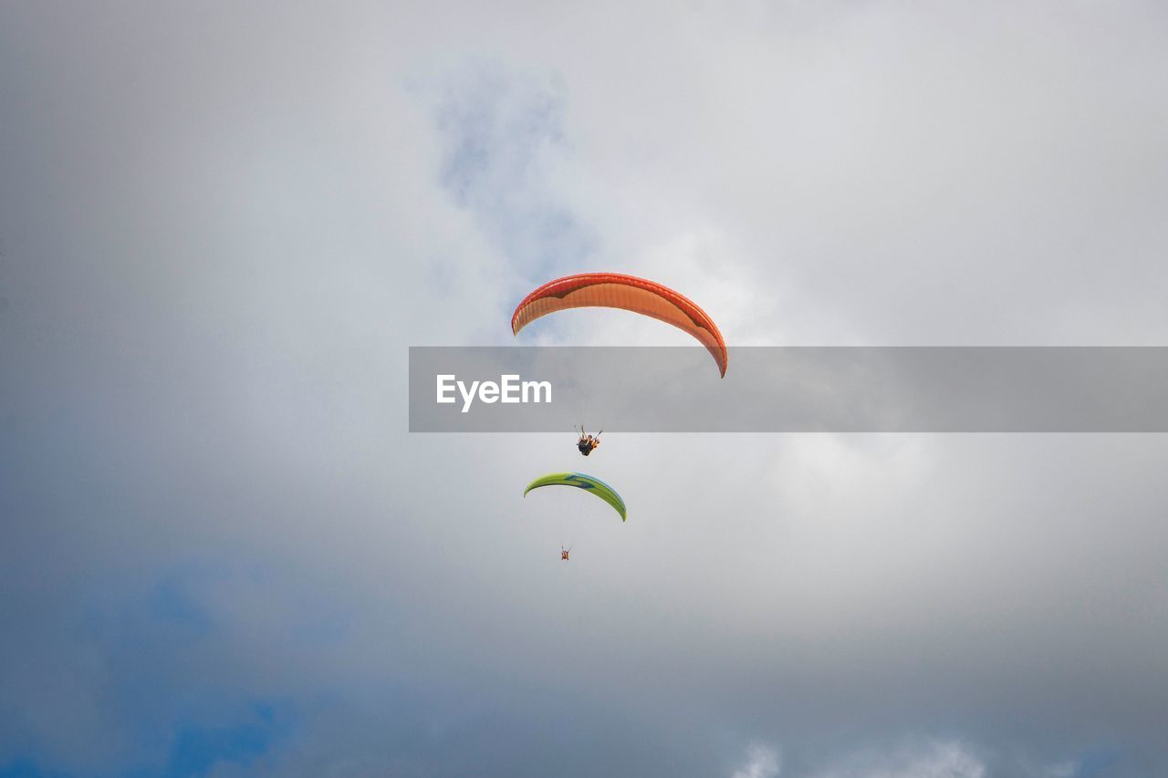 Low angle view of person paragliding against sky