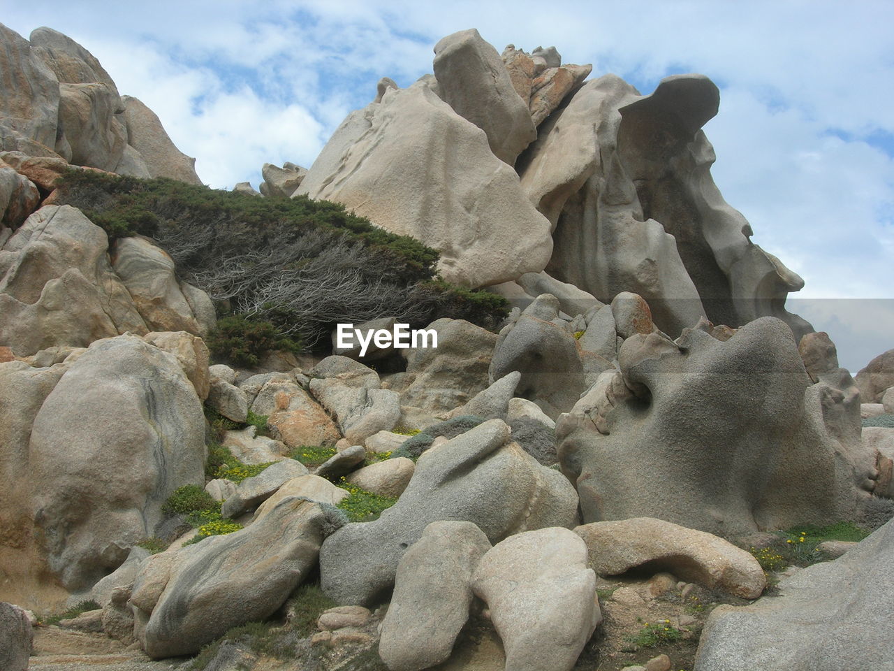 LOW ANGLE VIEW OF SCULPTURE AGAINST ROCKS