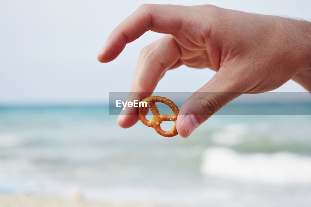 Close-up of hand holding pretzel