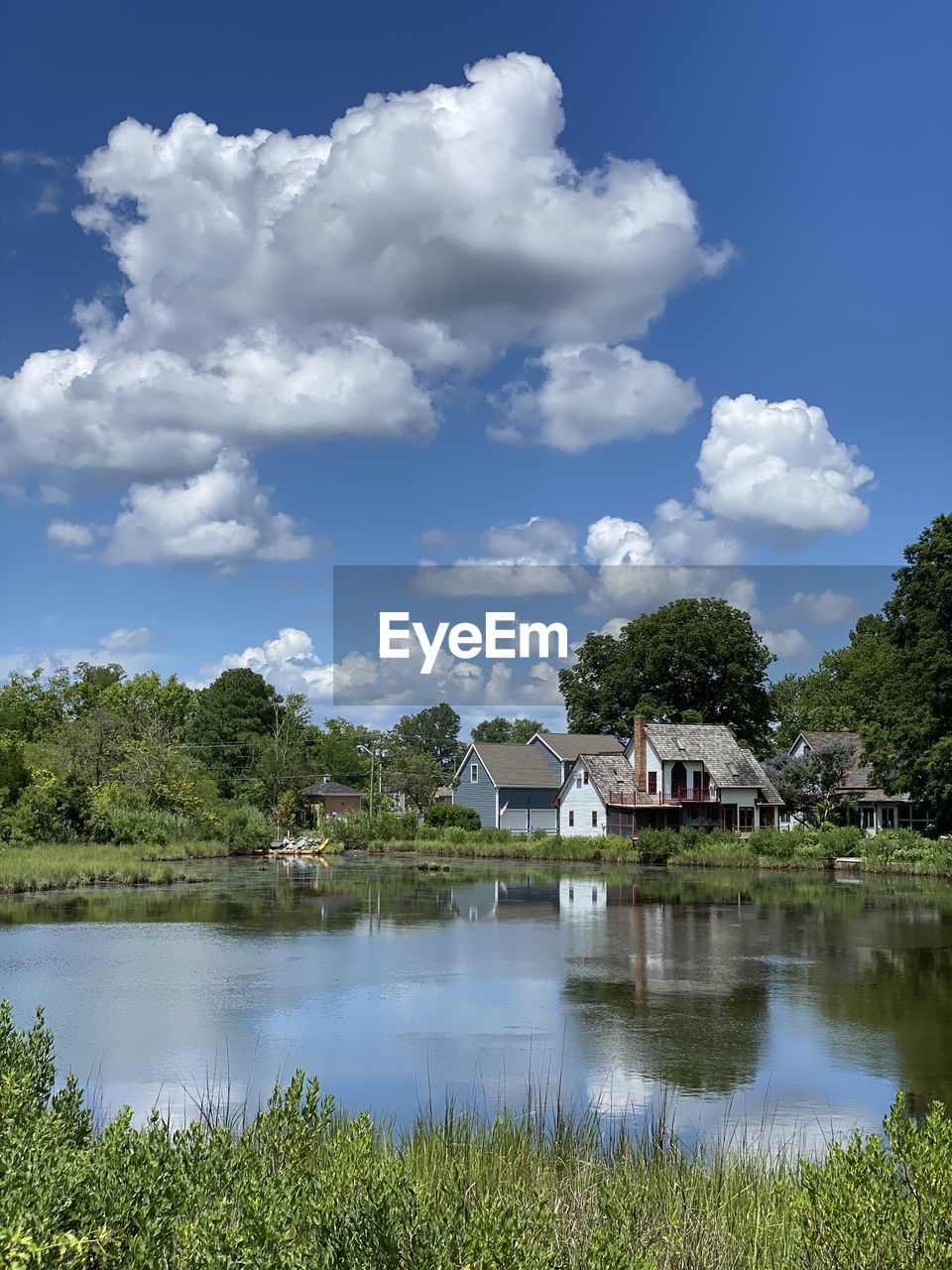 SCENIC VIEW OF LAKE AND TREES BY BUILDING AGAINST SKY