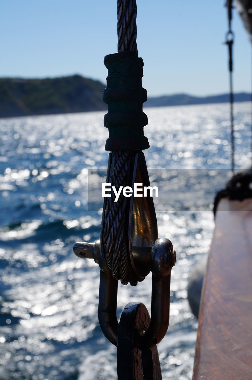 Close-up of rope tied to boat against sea