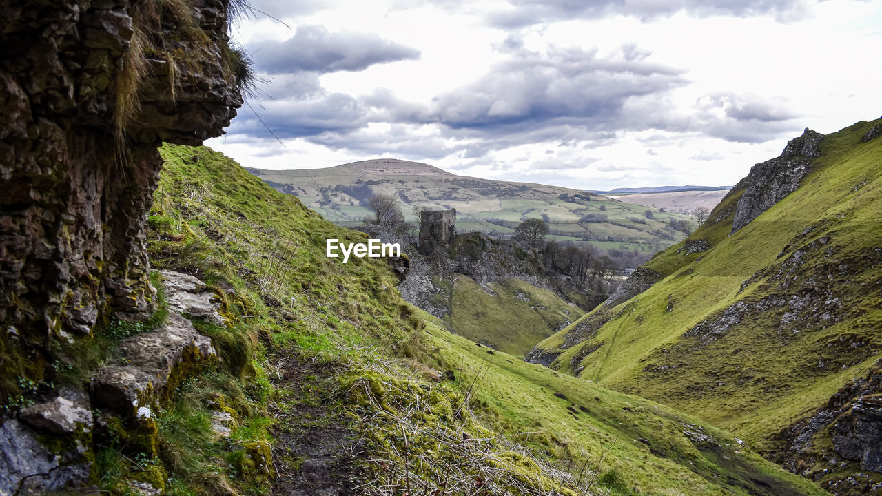 scenic view of mountains against cloudy sky