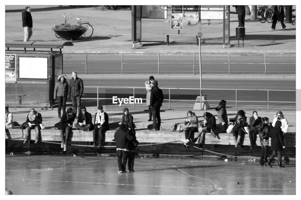 PEOPLE WALKING ON RAILROAD STATION PLATFORM