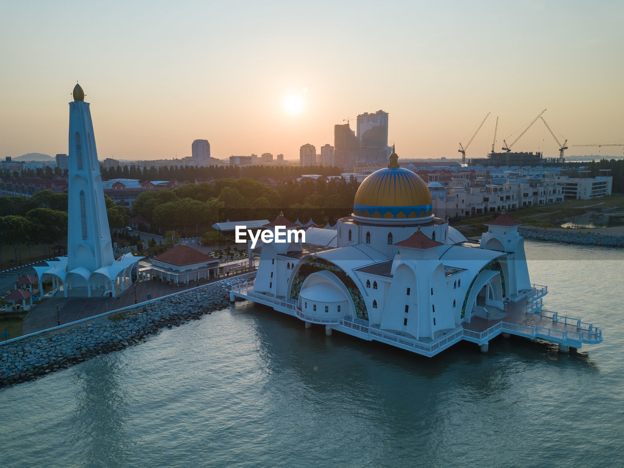 High angle view of white mosque in lake against sky during sunset