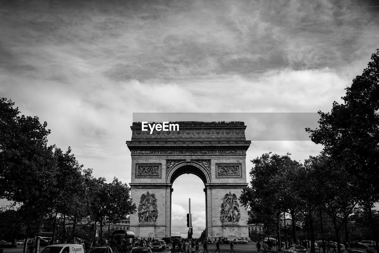 triumphal arch, architecture, travel destinations, arch, tree, monument, the past, history, black and white, memorial, city, plant, built structure, sky, monochrome photography, travel, cloud, monochrome, tourism, nature, landmark, gate, outdoors, car, building exterior, day, transportation, no people, low angle view, motor vehicle, mode of transportation, sculpture, park