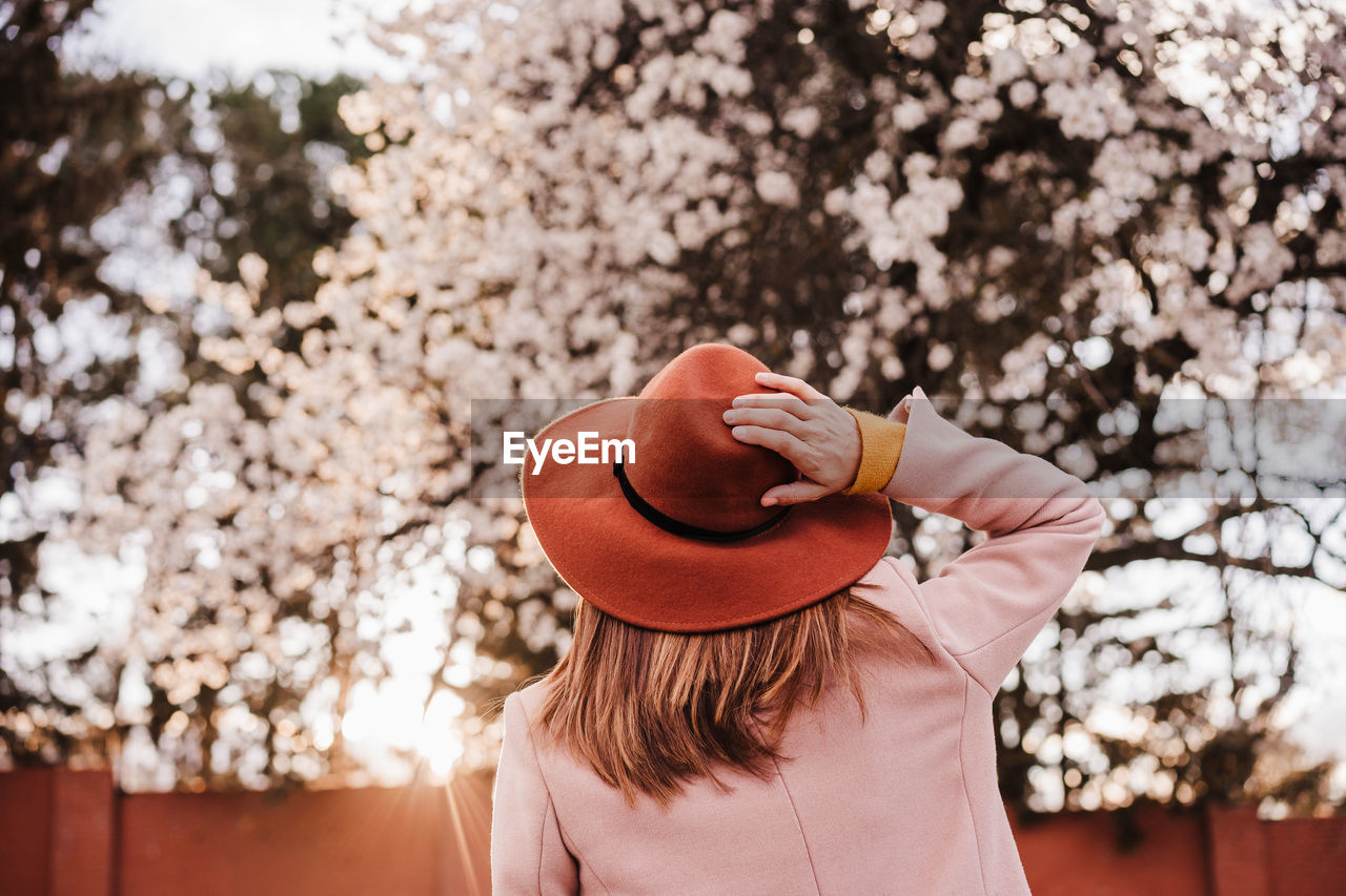 Portrait of woman wearing hat standing against plants