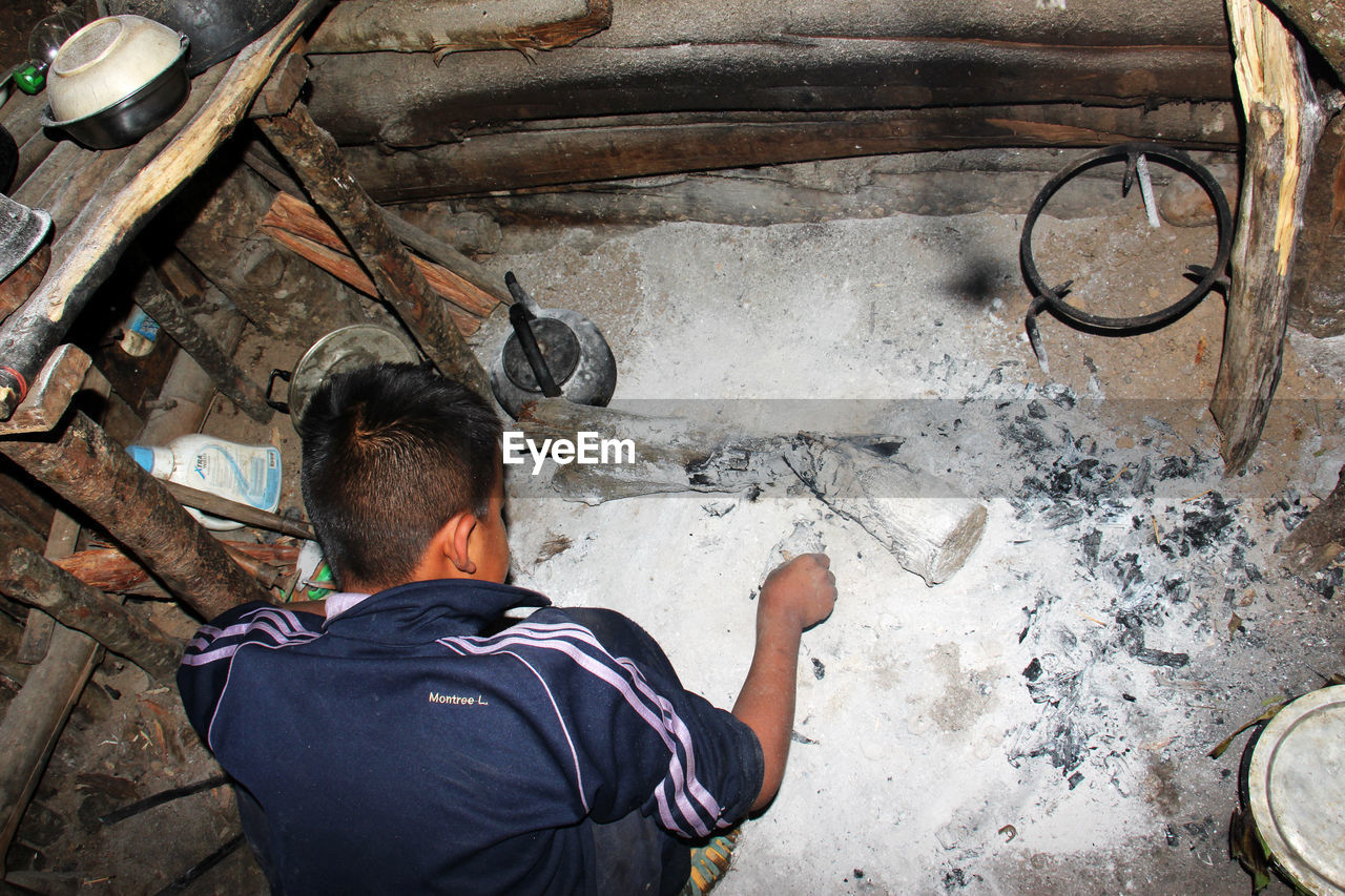 REAR VIEW OF MAN WORKING ON FLOOR