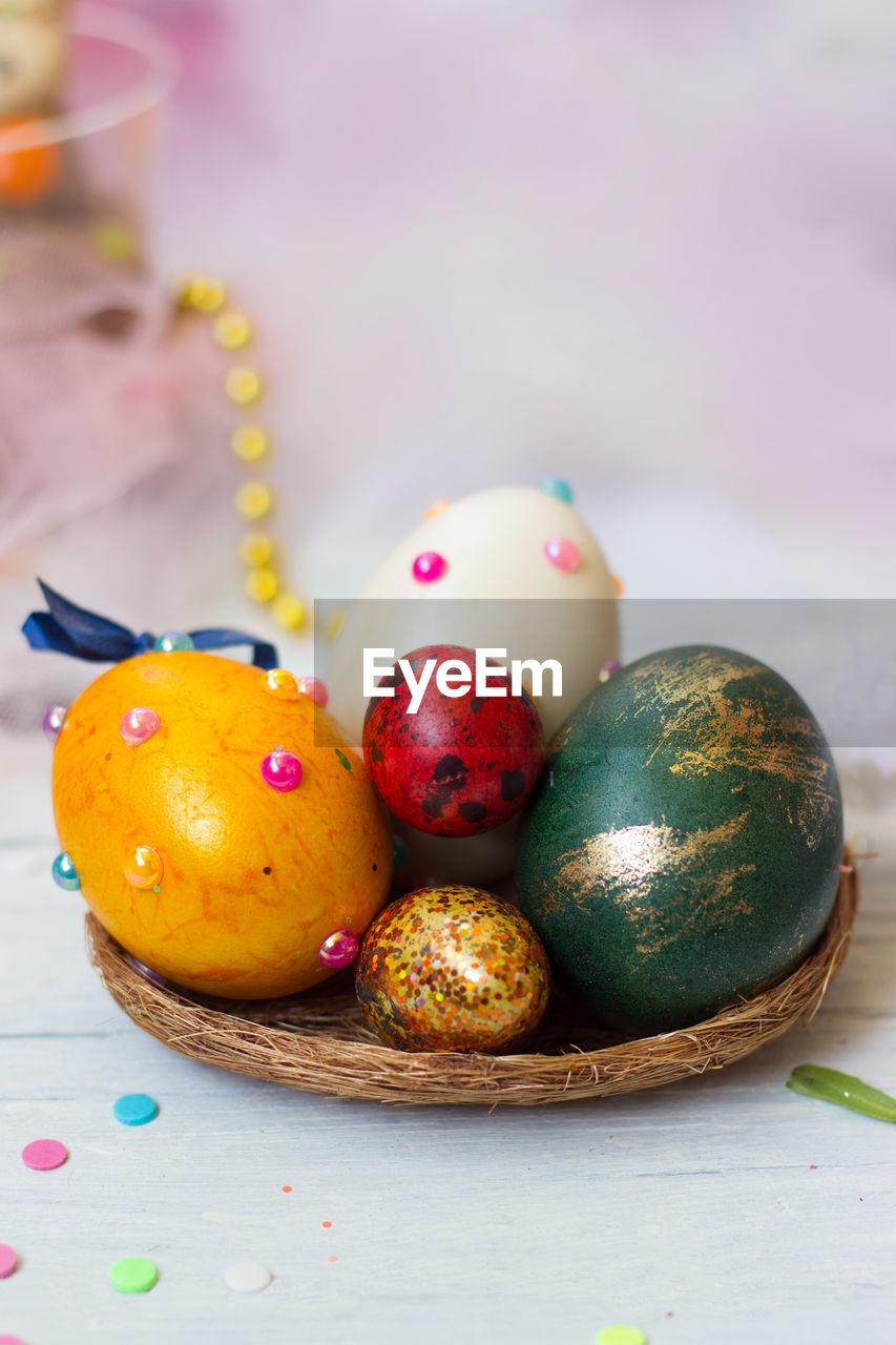 CLOSE-UP OF MULTI COLORED EGGS IN GLASS