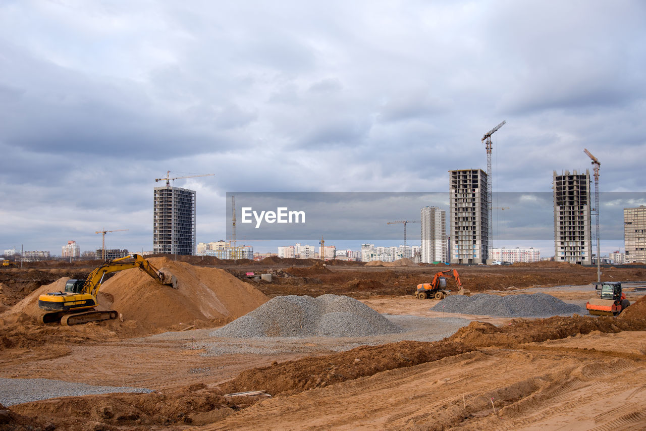 Group of the excavators and vibration single-cylinder road roller at the construction 