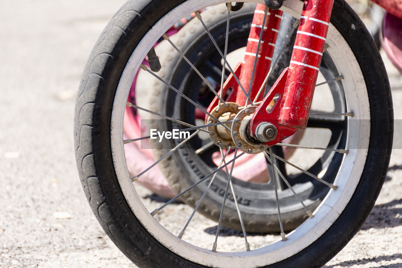 CLOSE-UP OF BICYCLE WHEEL ON STREET