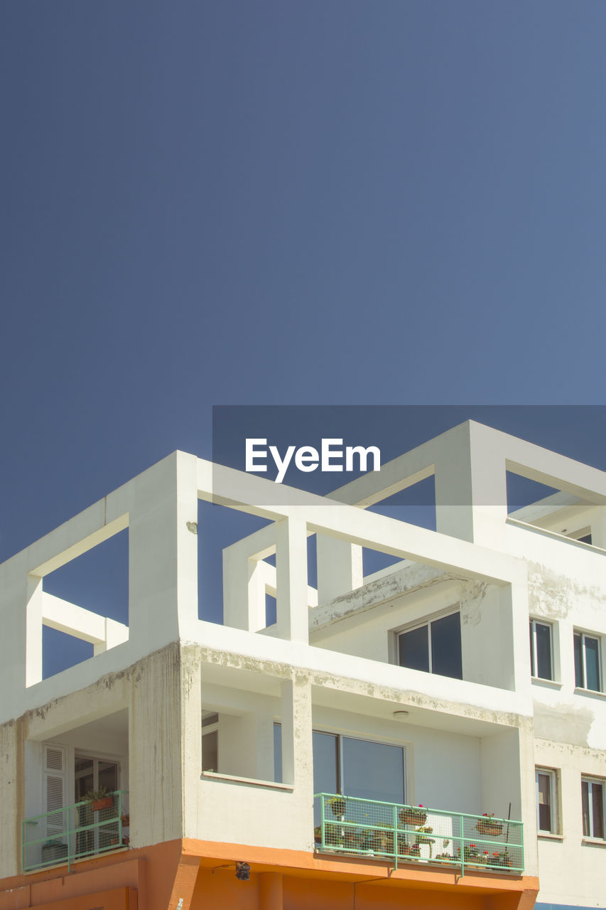 LOW ANGLE VIEW OF BUILDING AGAINST BLUE SKY