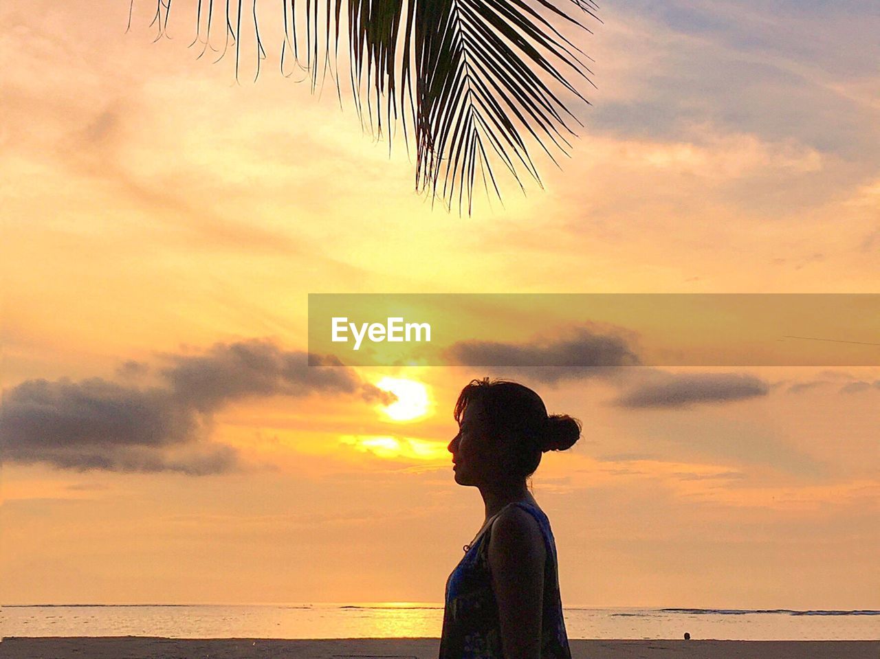 SILHOUETTE WOMAN STANDING AT BEACH DURING SUNSET