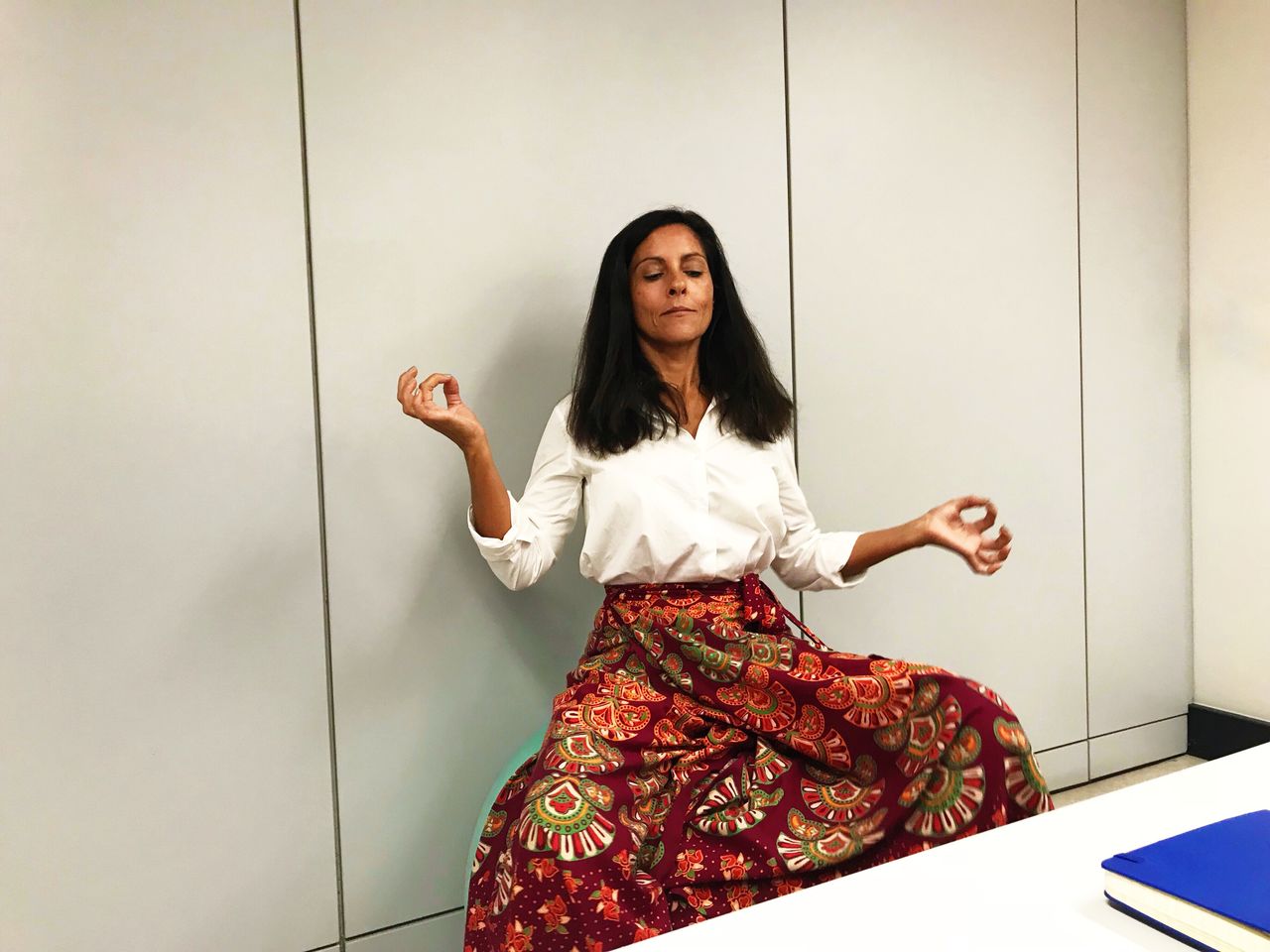 Woman doing yoga while sitting against wall