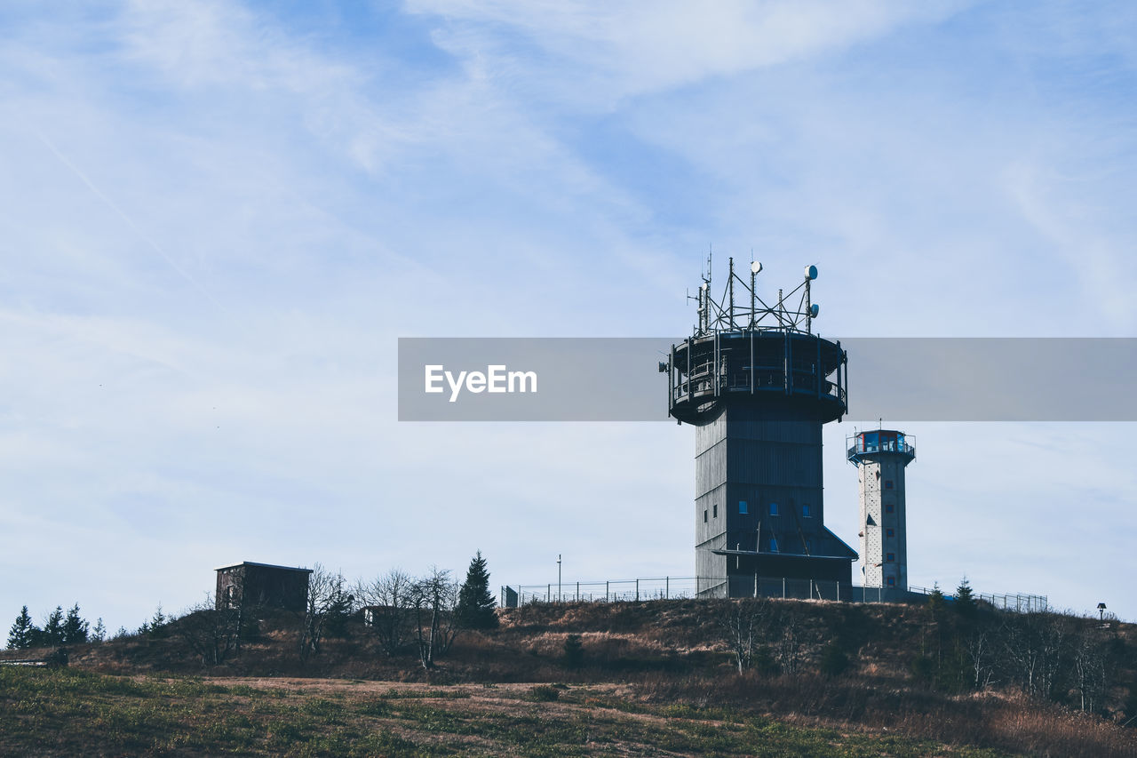 LOW ANGLE VIEW OF LIGHTHOUSE AT FACTORY AGAINST SKY