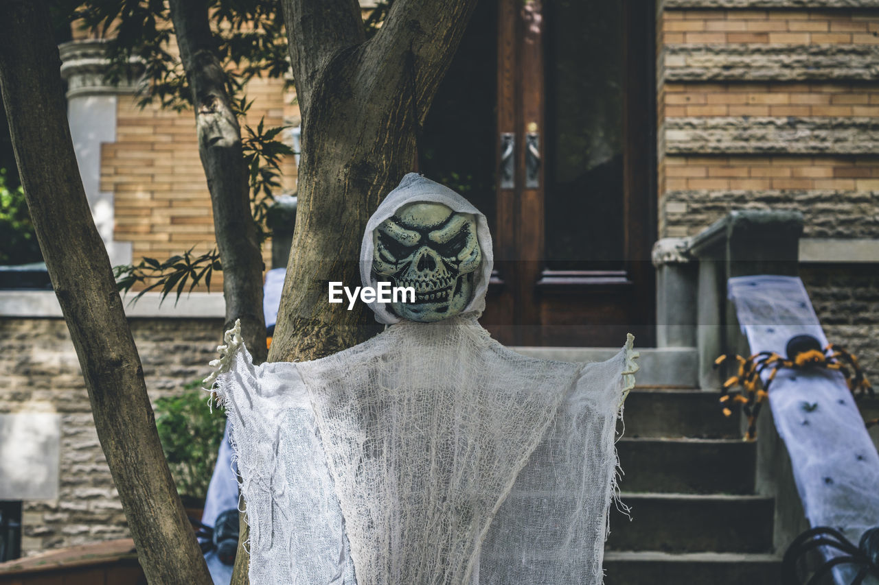 Halloween decoration of a skeleton and spiders at the stoop of a building